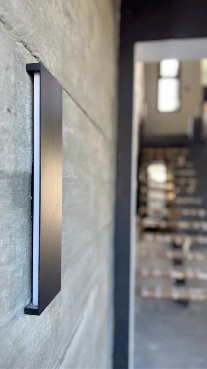 Detalhe de acabamento em concreto aparente com luminária instalada